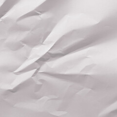 Fototapeta premium Crumpled white paper texture with visible creases and shadows.
