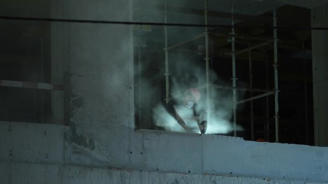 Concrete cutting process inside new building under construction showing structural work, construction technology and building development