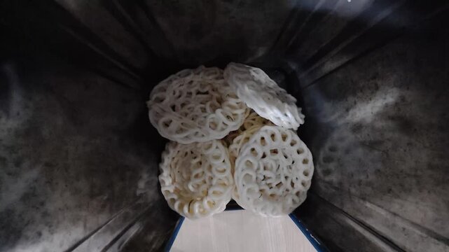 Traditional Indonesian kerupuk crackers stacked inside a rustic cooking vessel
