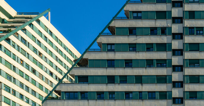 Edificios Politaria showcasing modern ziggurat architecture with cascading terraces and repeating green window shutters against a clear blue sky, forming abstract geometric patterns