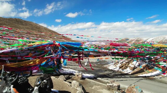 Prayer flags and stones revealing a Tibetan plateau road