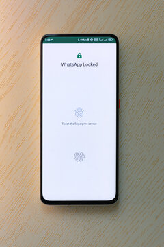 Smartphone showing locked messaging app with fingerprint authentication screen