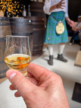 D&eacute;gustation d'un verre de whisky dans une distillerie avec un &eacute;cossais en kilt
