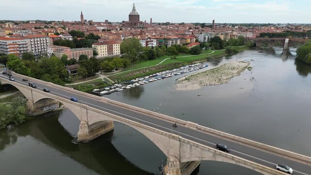 Europe, Italy, Pavia &ndash; drone views of the Ticino River, dried up due to drought and aridity - global warming and climate change in Ponte Coperto , Duomo cathedral and bridge with traffic car 
