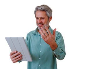 Mature man engaging in a video call on a tablet, gesturing during an online meeting, communicating remotely © Komora