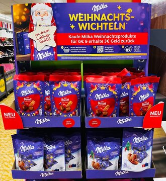 Germany, Paderborn, September 19. 2026, Milka Christmas Secret Santa Display Shelf Featuring Various Christmas Products and a Cashback Promotion