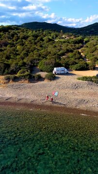 Experience the breathtaking landscapes of Villasimius, Sardinia, Italy, where emerald waters meet serene beaches. A couple on vacation in a camper van, a man and woman walking on the beach