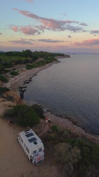 Witness the breathtaking beauty of Cagliari, Sardinia at twilight. A couple on vacation in a camper van watching the sunset
