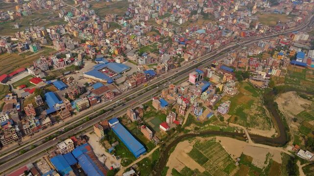 Aerial view of a vulnerable squatter settlement built along a wide, muddy riverbank exposed to severe flood risks in Kathmandu
