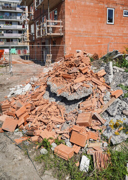 Pile of orange bricks waste and debris at new house construction site