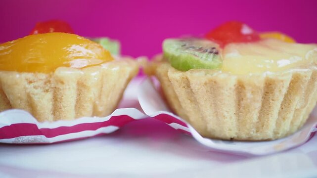 Close up on fruit tartlets with colorful toppings in motion