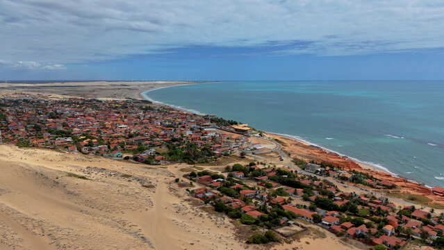 Aerial drone view of Canoa Quebrada coastal village, sand dunes, and ocean in Brazil