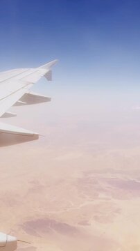 Aerial view from airplane wing over desert landscape.