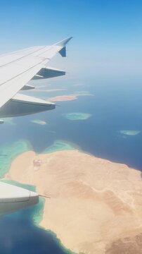 Aerial view from airplane over clear blue ocean and sandy islands.Red sea