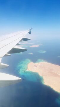 Scenic view from airplane window over turquoise waters and desert coastline.Red sea