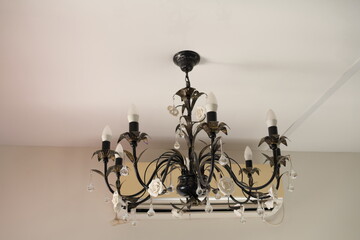 Vintage chandelier on the wall in a room with white walls © Viktor