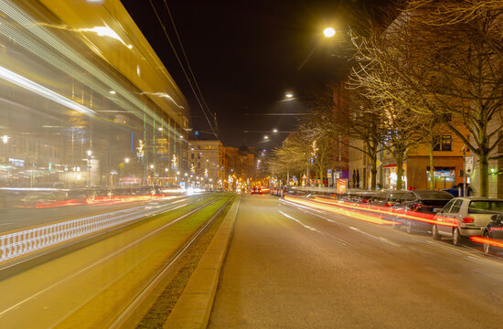 Breiter Weg (Broadway) in Magdeburg, Germany, in the evening during the christmas season, blurred traffic with light traces from tail lights of tram and cars