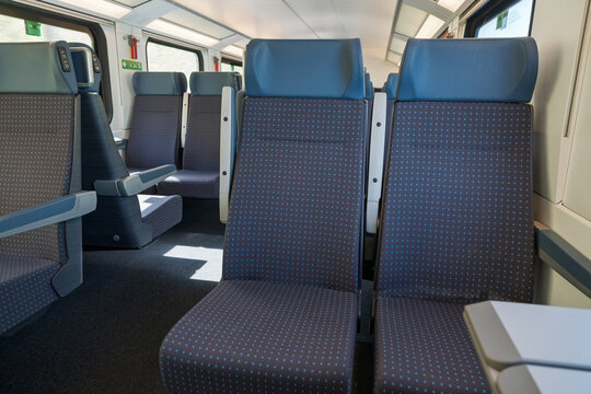 Modern empty train carriage with blue passenger seats