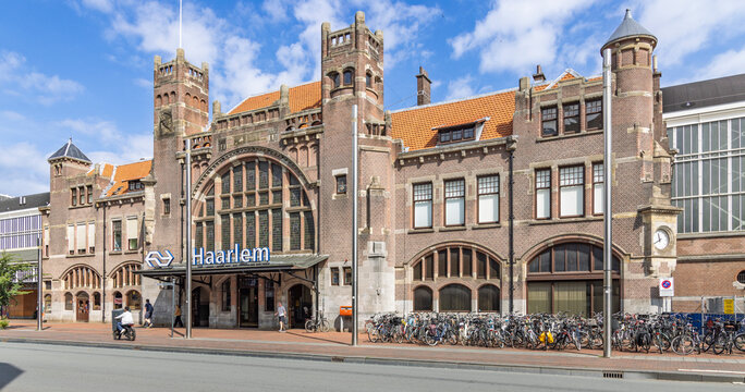 Haarlem, Netherlands - 16 August 2026 - Historic exterior view of Haarlem railway station with iconic brick architecture and bicycle parking.