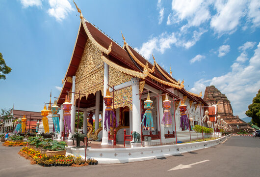 Traditional Assembly Hall of Wat Chedi Luang Temple Decorated with Colorful Hanging Lanterns Against Blue Sky, Historic Landmark in Chiang Mai, Thailand