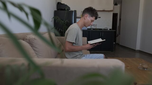 Reviewing monthly household expenses at home, thoughtful man studies handwritten budget notes while organizing personal finances and planning everyday spending