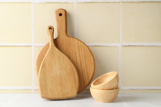 Different kitchenware on table near yellow tiled wall