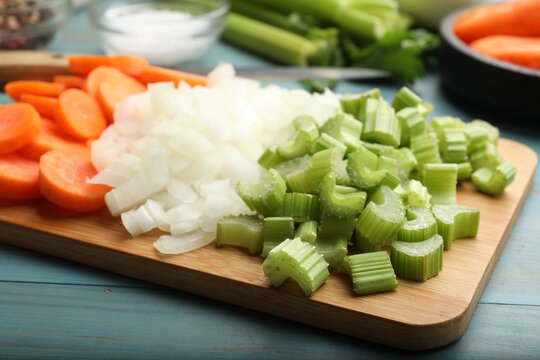 Fresh celery, carrots, onions and spices on light blue wooden table, closeup