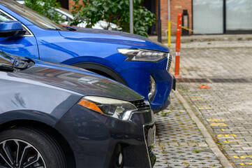Close-up of Car Headlights and Front Bumper in Parking Area © Михаил Шорохов