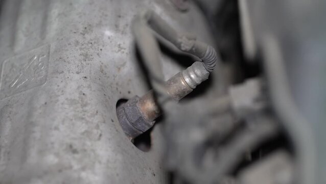 Close-up of a car lambda oxygen sensor in exhaust manifold.