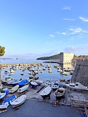Fototapeta premium Boats docked in a harbor with a fort in the background