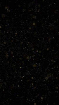 Golden blurred particles loop flying vertical black background. Concept holiday decoration animation.