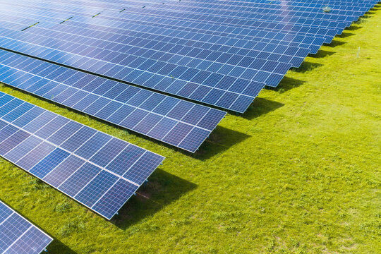 Aerial drone view of solar panels in a renewable energy farm. Sustainable green power station for clean electricity production and environmental technology infrastructure.