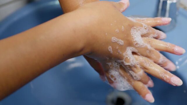 Woman washing hands with soap and water