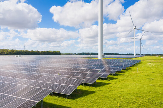 Aerial drone view of solar panels and wind turbines in a renewable energy farm. Sustainable green power station for clean electricity production and environmental technology infrastructure.