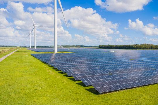 Aerial drone view of solar panels and wind turbines in a renewable energy farm. Sustainable green power station for clean electricity production and environmental technology infrastructure.