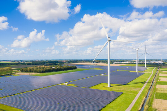 Aerial drone view of solar panels and wind turbines in a renewable energy farm. Sustainable green power station for clean electricity production and environmental technology infrastructure.