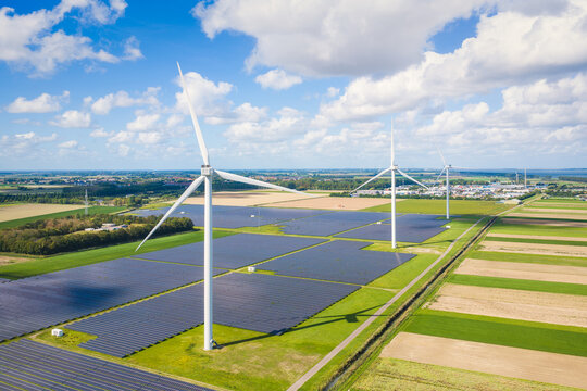 Aerial drone view of solar panels and wind turbines in a renewable energy farm. Sustainable green power station for clean electricity production and environmental technology infrastructure.