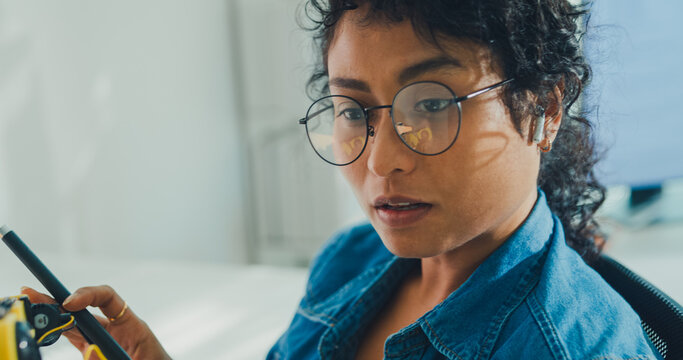 Close-up African American female robotics engineer discussing mechanical part on video call in laboratory. Remote work, virtual training, online meeting, future technology, technical support concept.
