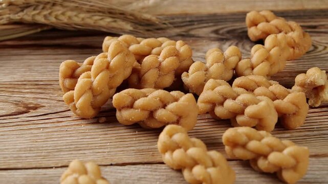 raditional Tianjin Mahua, golden fried dough twist pastry, famous local specialty snack of Tianjin, crispy twisted dough food with various nut fillings, classic Chinese pastry. Filmed on 2024-09-11.