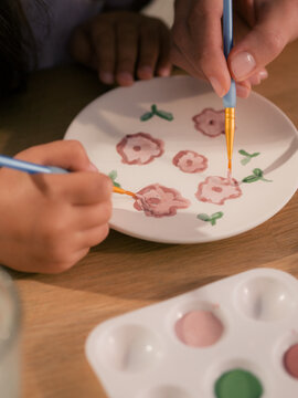 Parent and kid painting flowers together