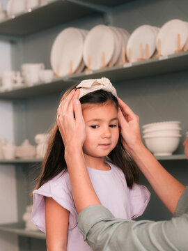Mom helping her daughter with getting ready