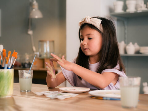 Child painting dish at workshop