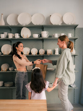 Seller giving to clients their purchase at ceramic store