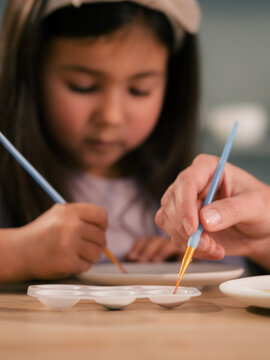 Child painting at studio with parent