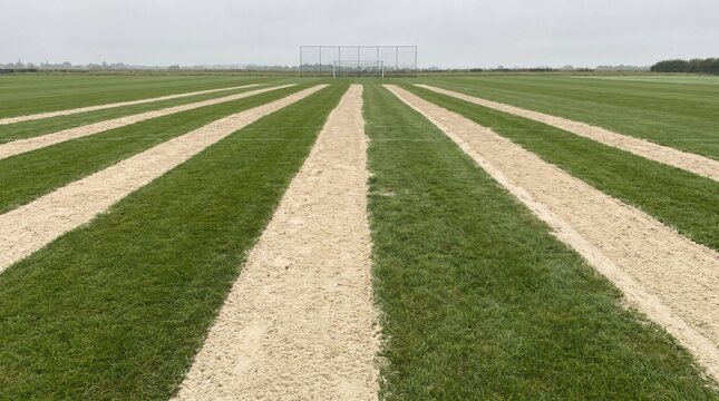 Sand Drainage Bands Across A Sports Pitch as Invisible Investment Metaphor