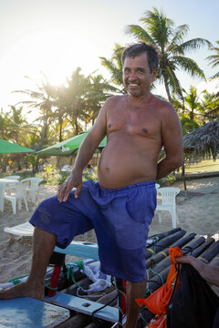 Man Standing on Boat by the Beach