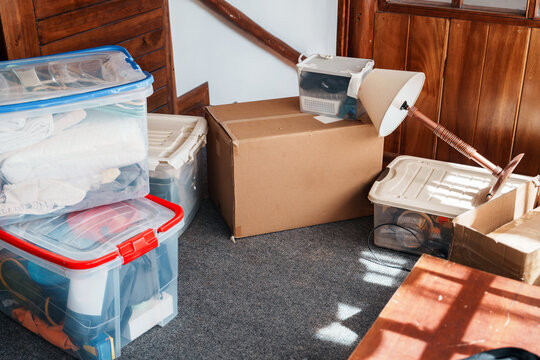 Cardboard Box and Plastic Containers Stacked on Moving Day