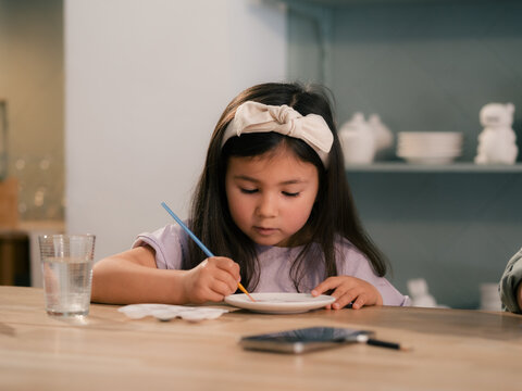 Engaged girl is painting at workshop during classes