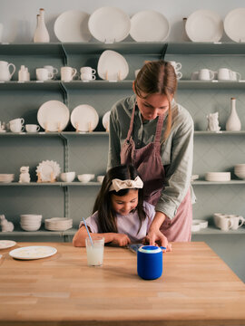 Mom helping to daughter to arrange playlist on smartphone