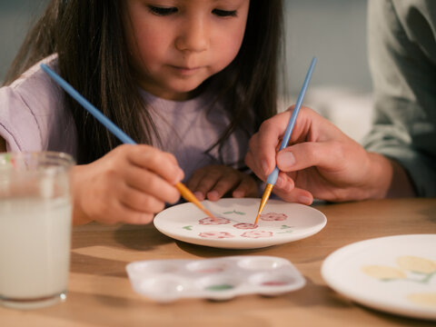 Girl enjoying painting with her mom